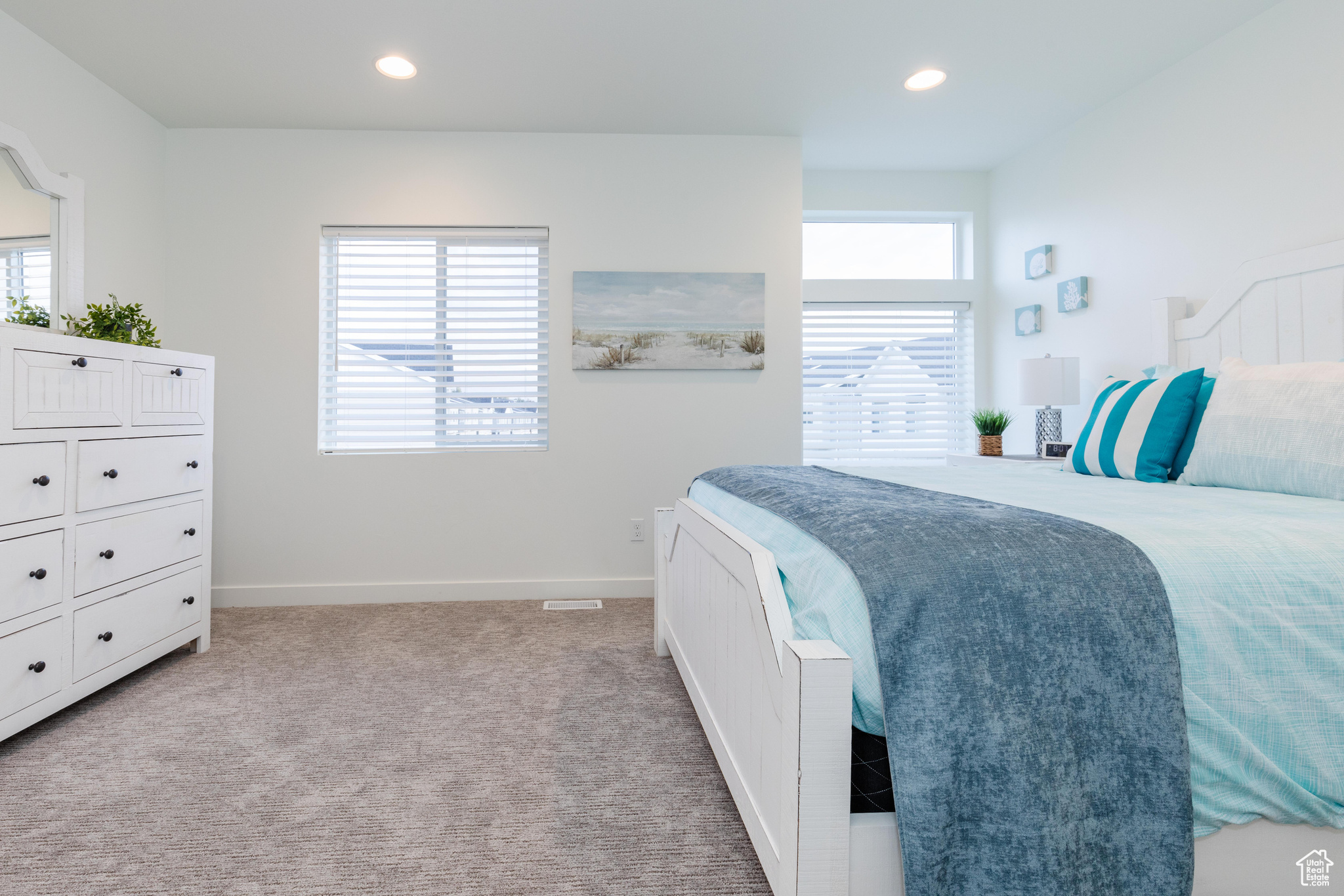 Bedroom featuring multiple windows and light colored carpet
