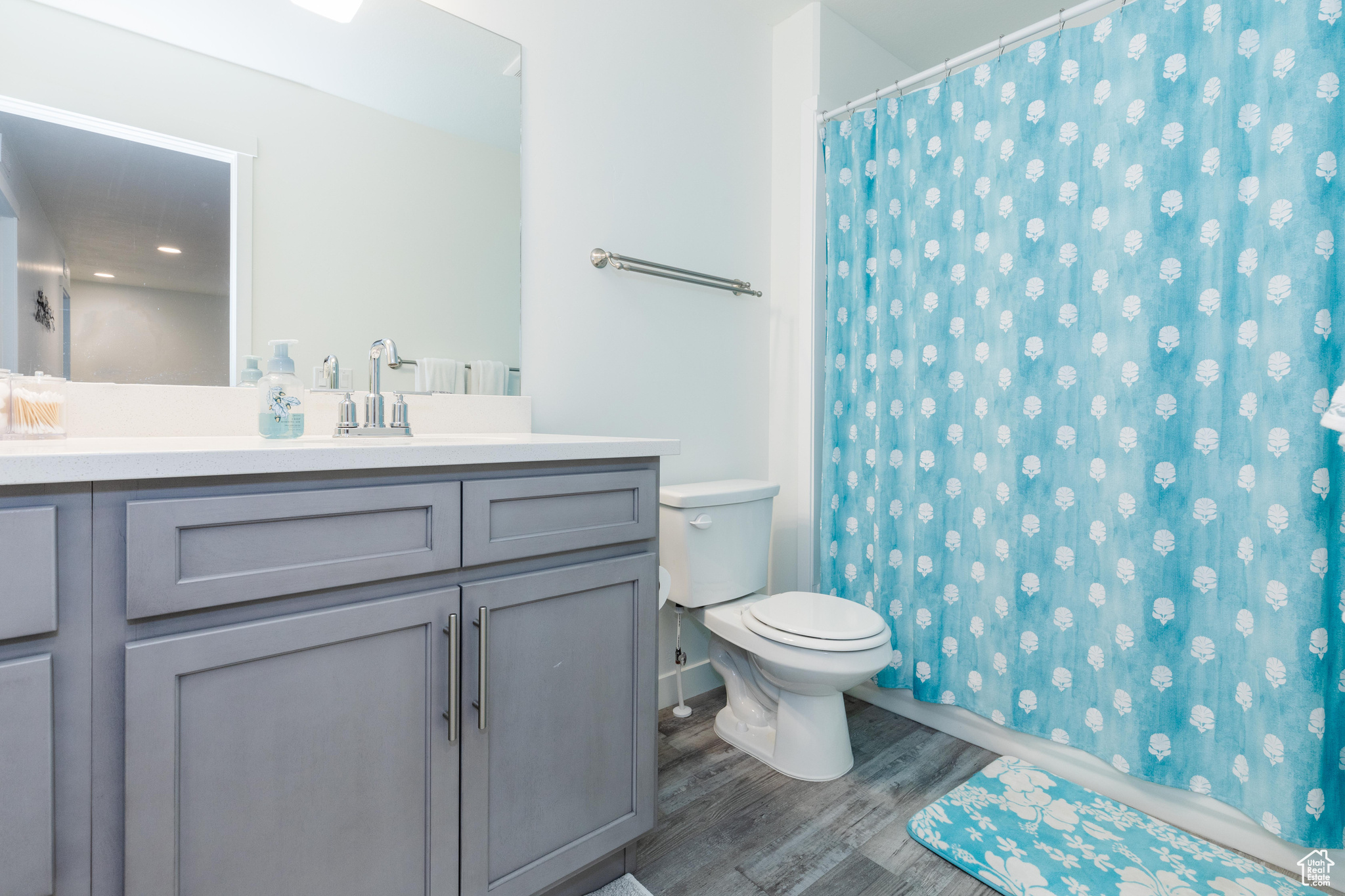 Bathroom featuring vanity, wood-type flooring, toilet, and walk in shower