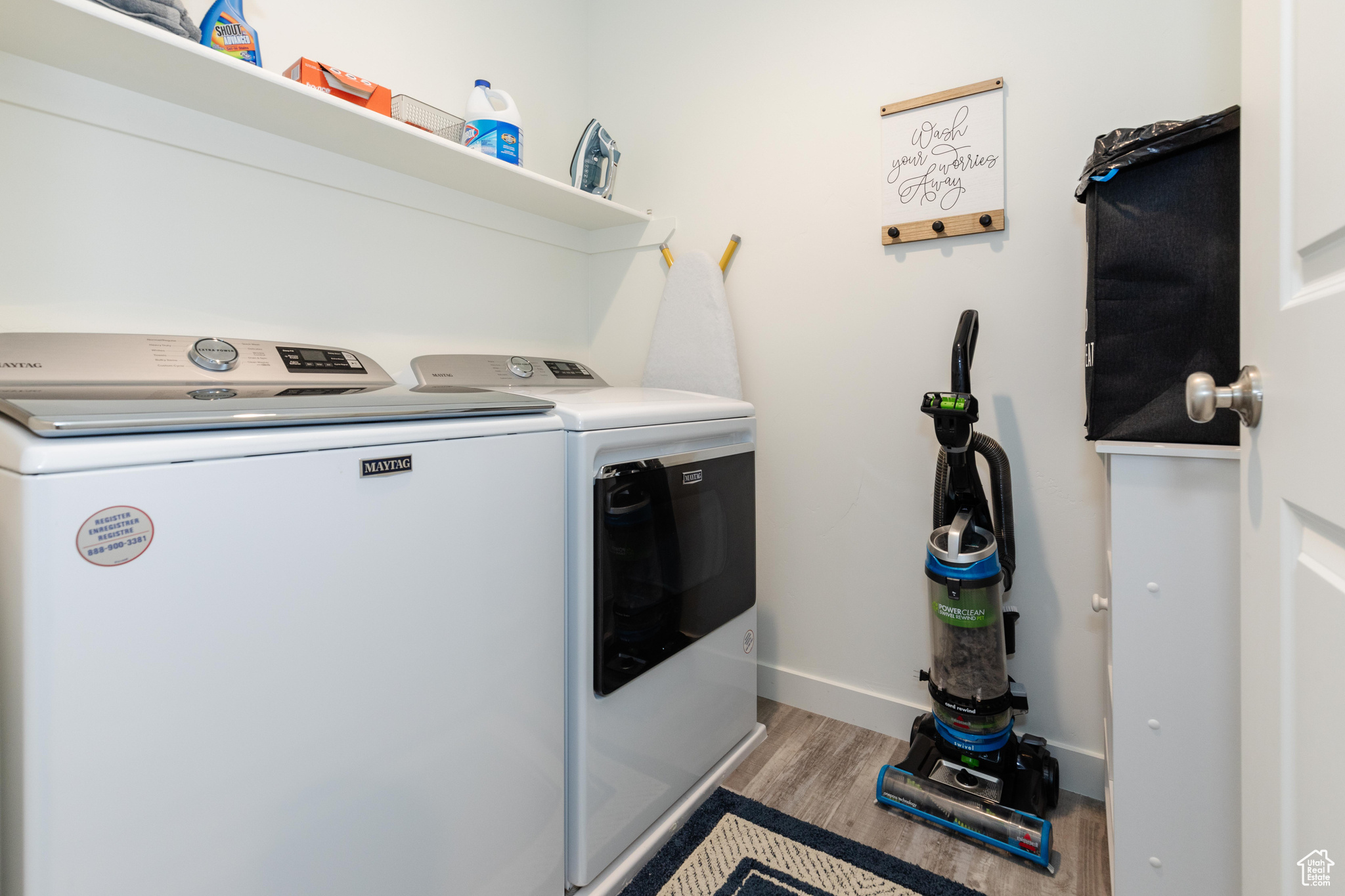 Laundry area with independent washer and dryer and light wood-type flooring