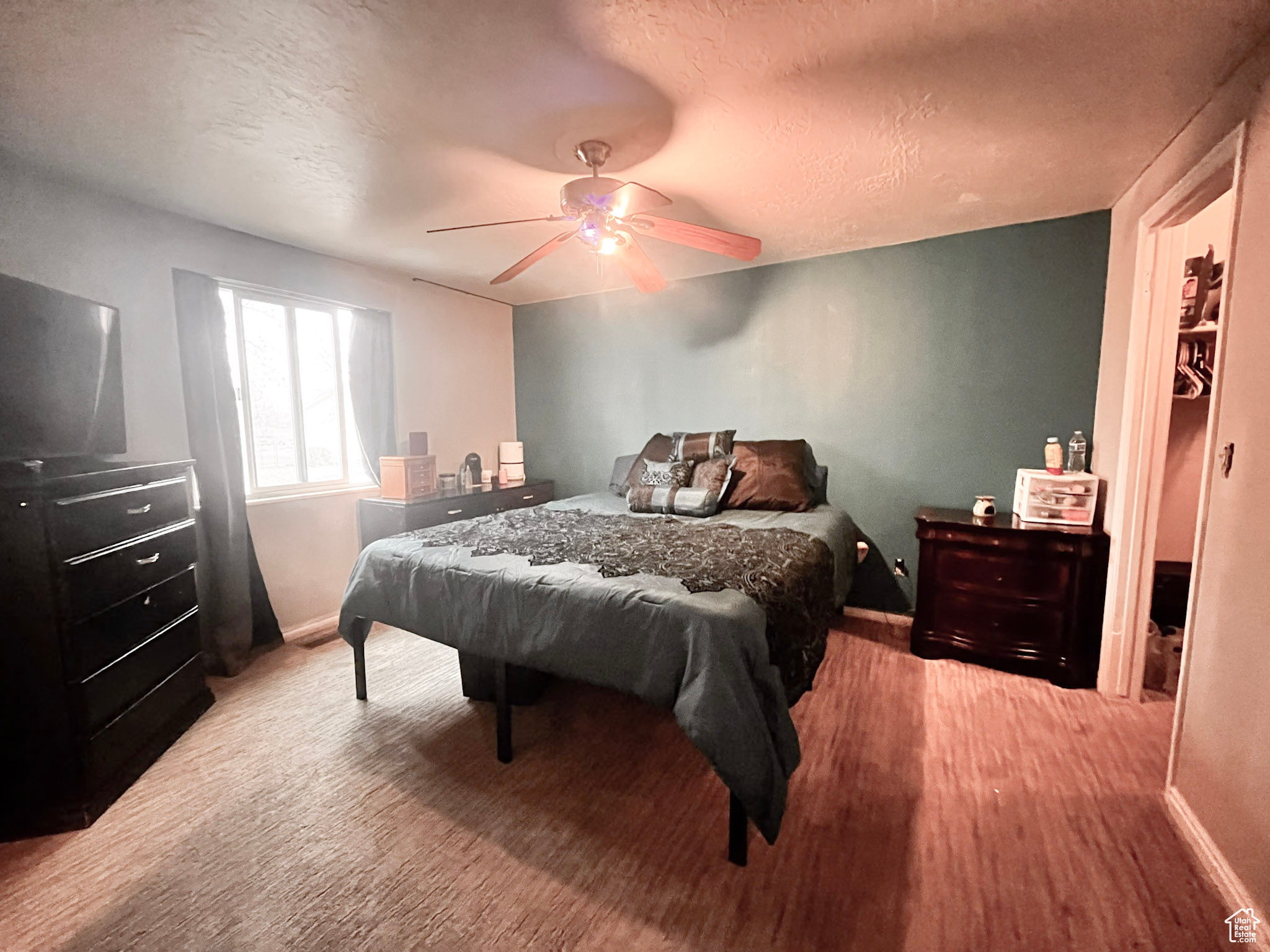 Bedroom with ceiling fan and a textured ceiling
