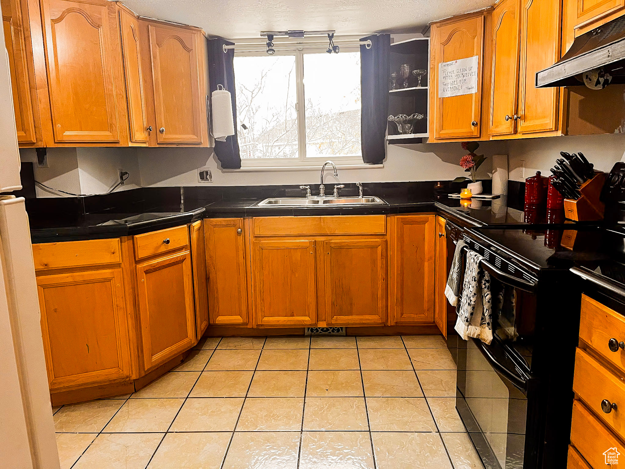 Kitchen with sink, electric range, and light tile patterned floors