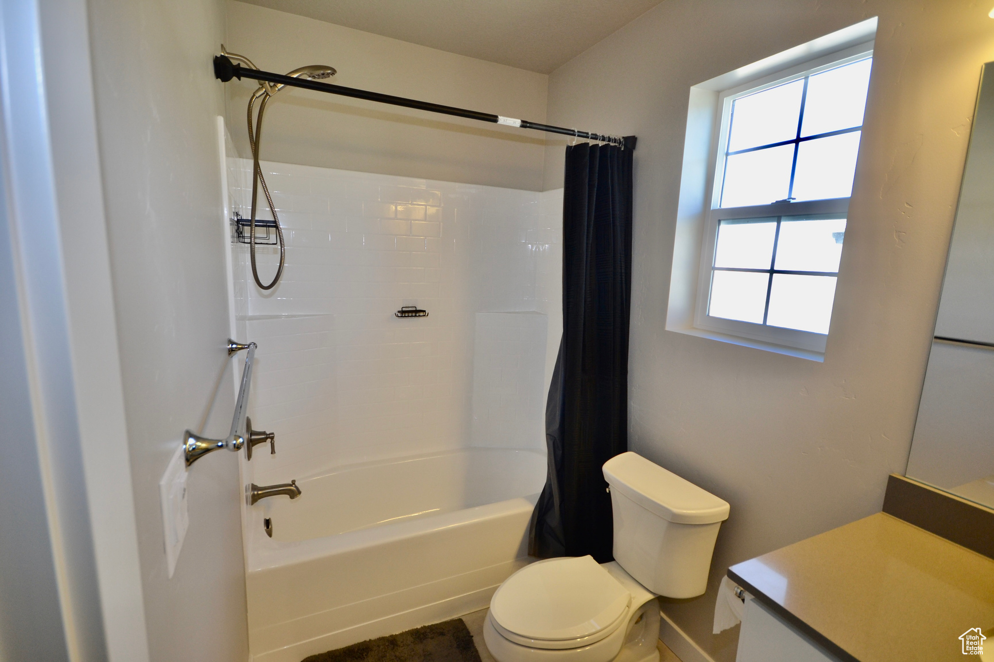 Full bathroom with shower / bath combination with curtain, vanity, and toilet