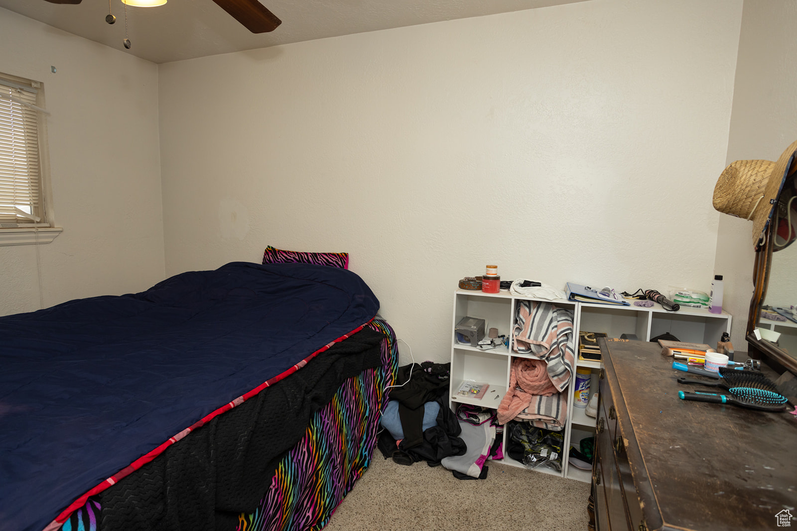 Carpeted bedroom featuring ceiling fan
