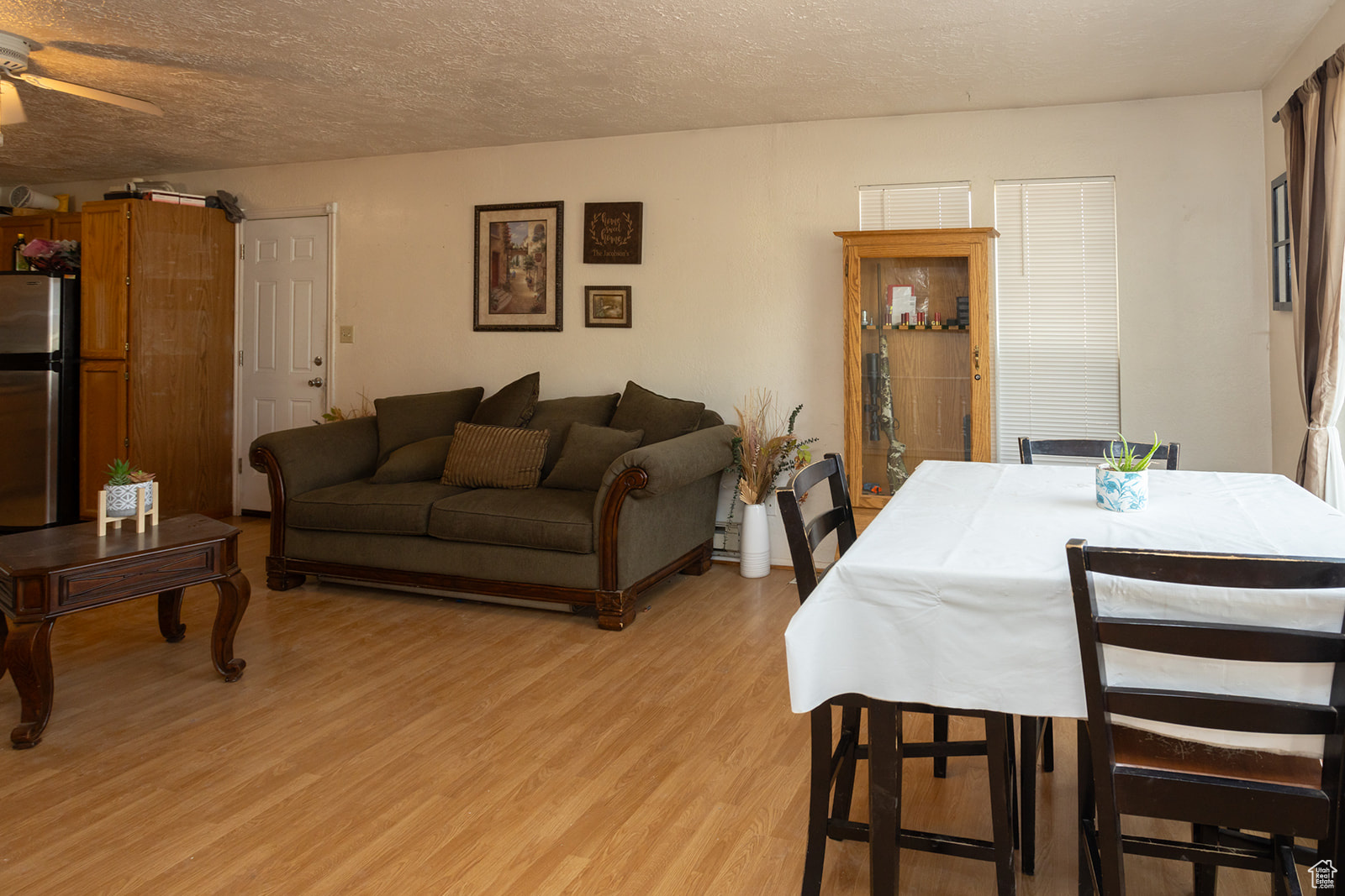 Dining room featuring ceiling fan, a textured ceiling, and light wood-type flooring