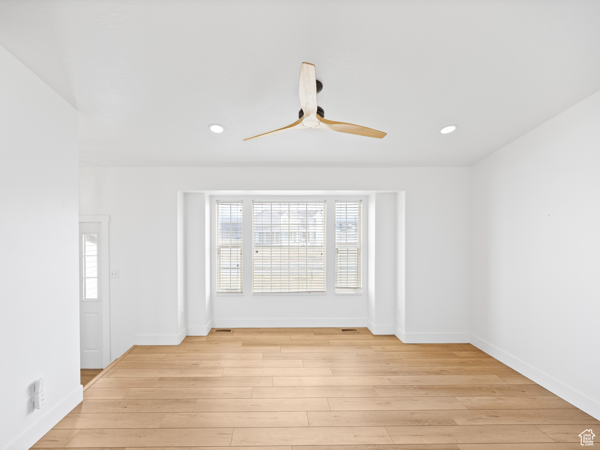Unfurnished room with ceiling fan and light wood-type flooring