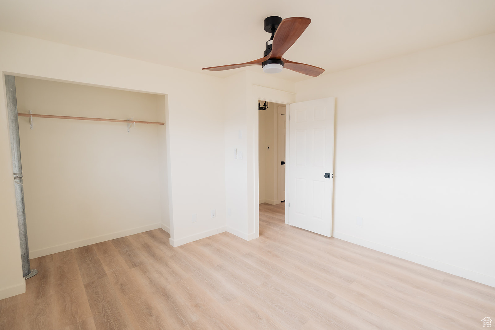 Unfurnished bedroom featuring ceiling fan, light wood-type flooring, and a closet