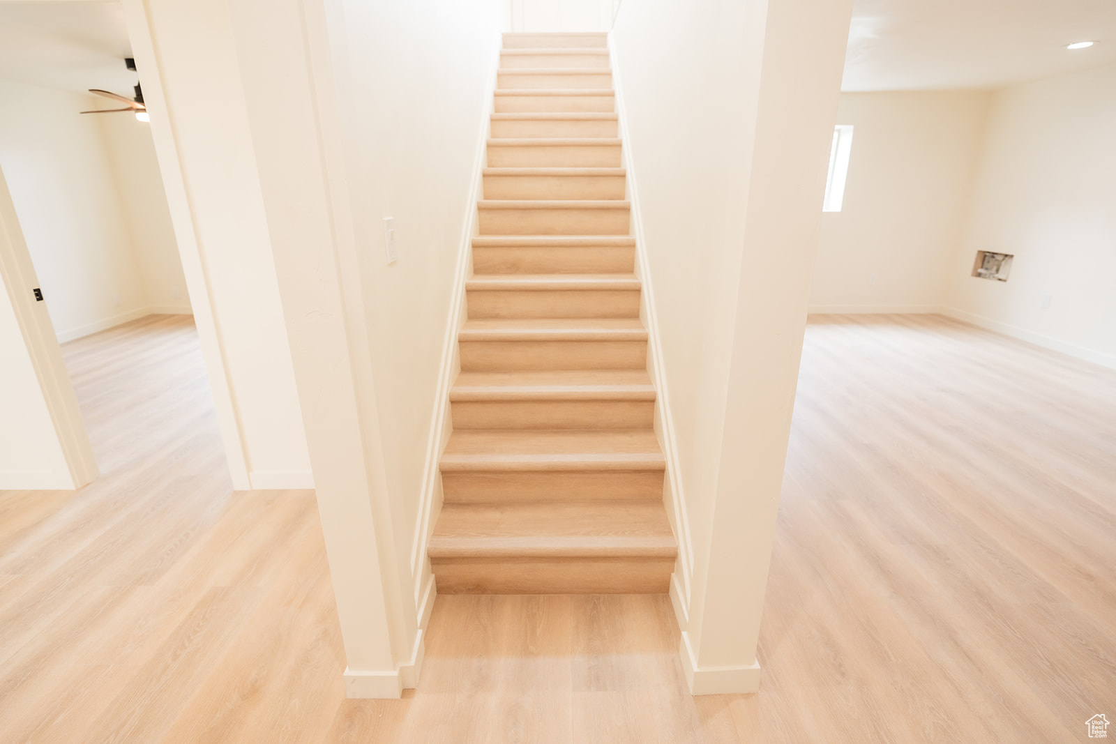 Stairs with ceiling fan and hardwood / wood-style floors