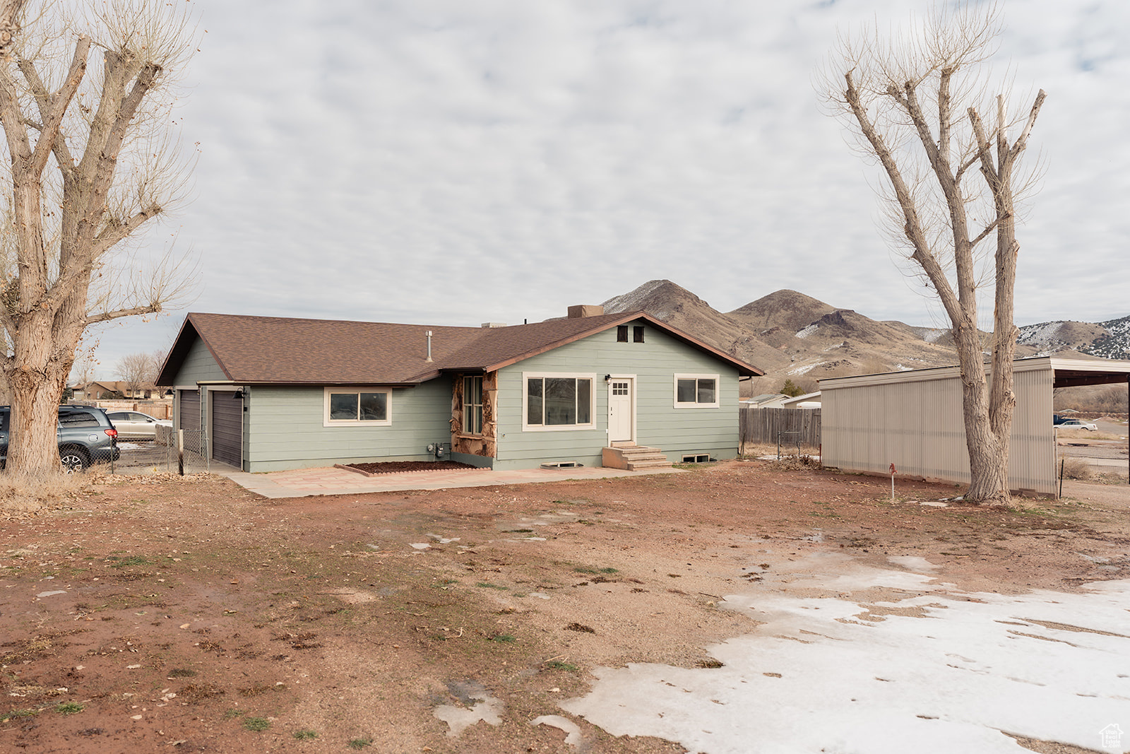 Rear view of property with a mountain view and a patio