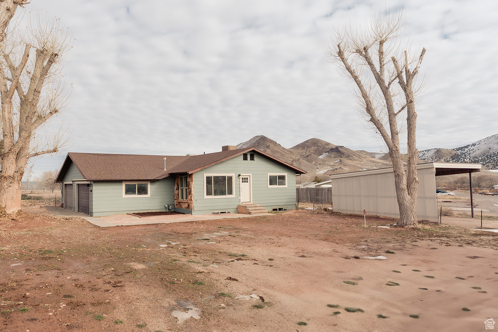 Rear view of house featuring a mountain view, a garage, and a carport