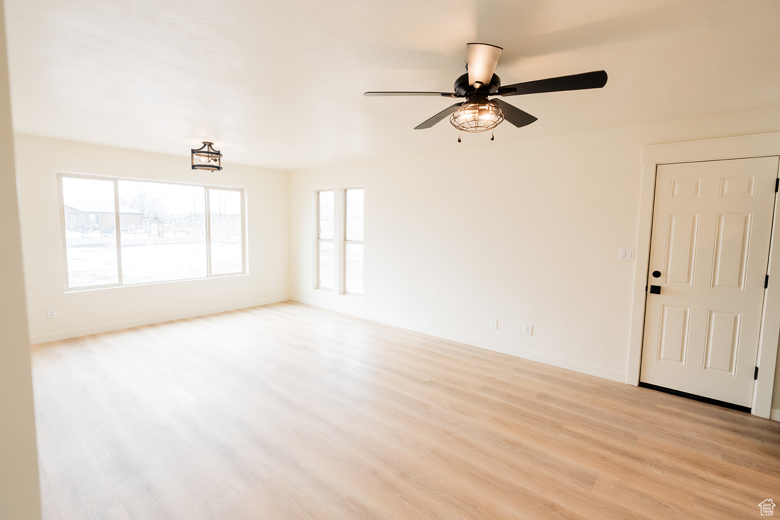 Unfurnished living room with ceiling fan and light wood-type flooring