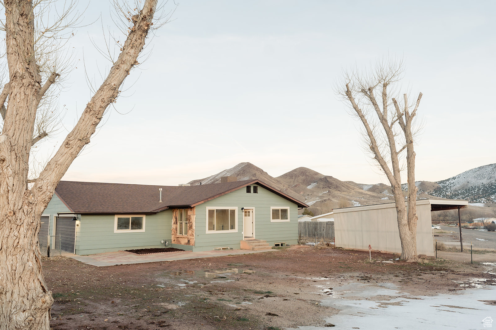 Back house at dusk with a garage and a mountain view