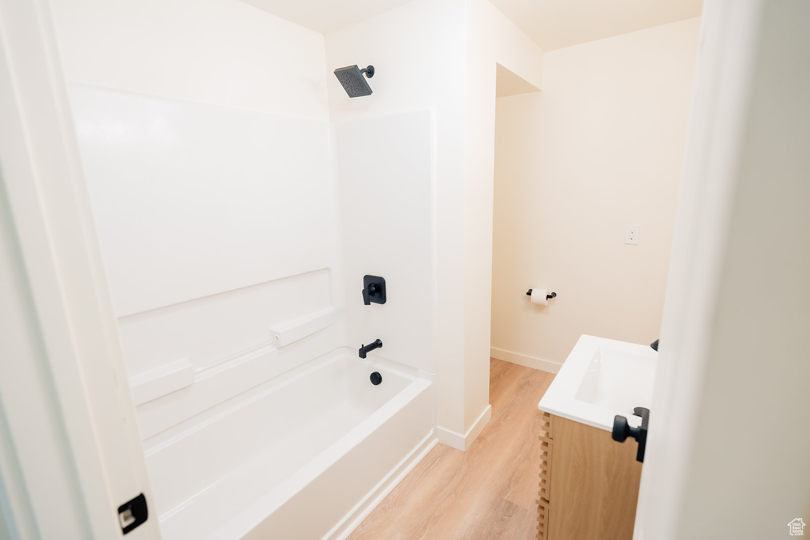 Bathroom featuring vanity, hardwood / wood-style floors, and shower / washtub combination