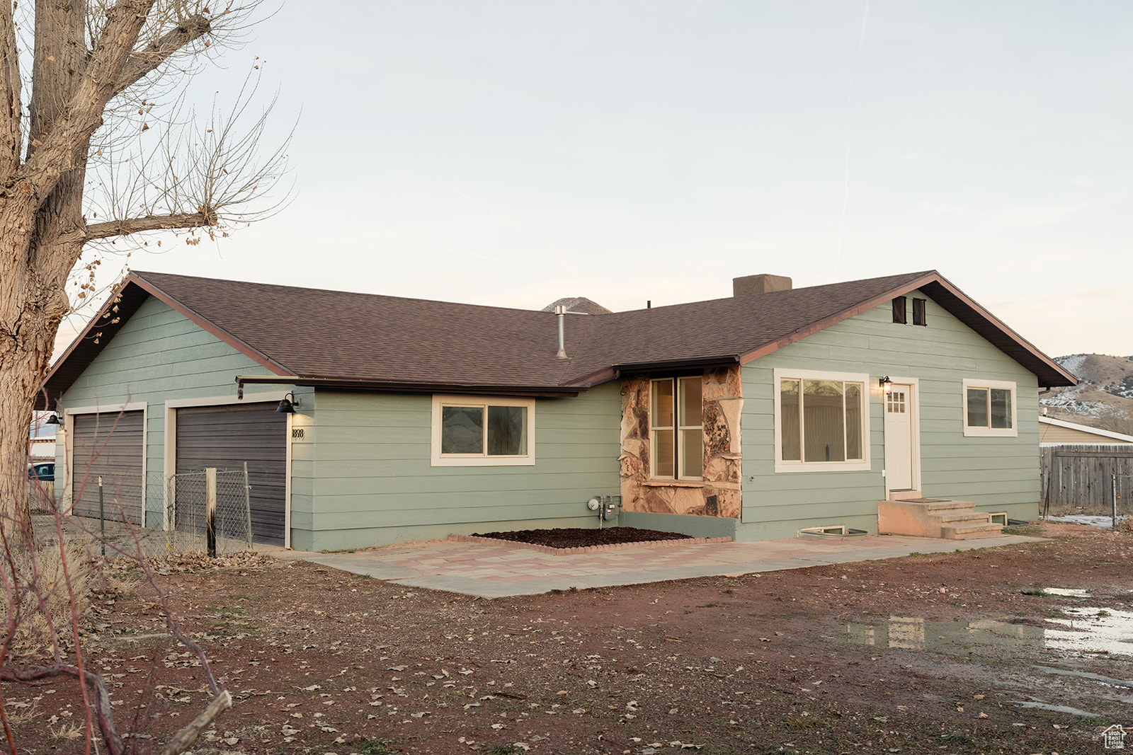 Back house at dusk featuring a garage
