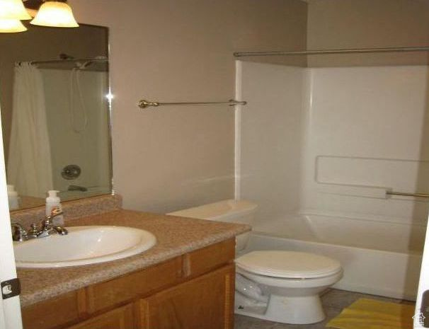 Full bathroom featuring vanity, bathtub / shower combination, and toilet