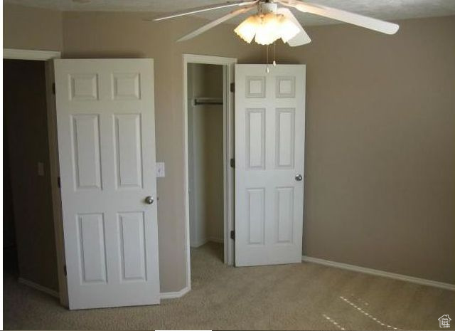 Unfurnished bedroom with carpet floors, ceiling fan, and a closet