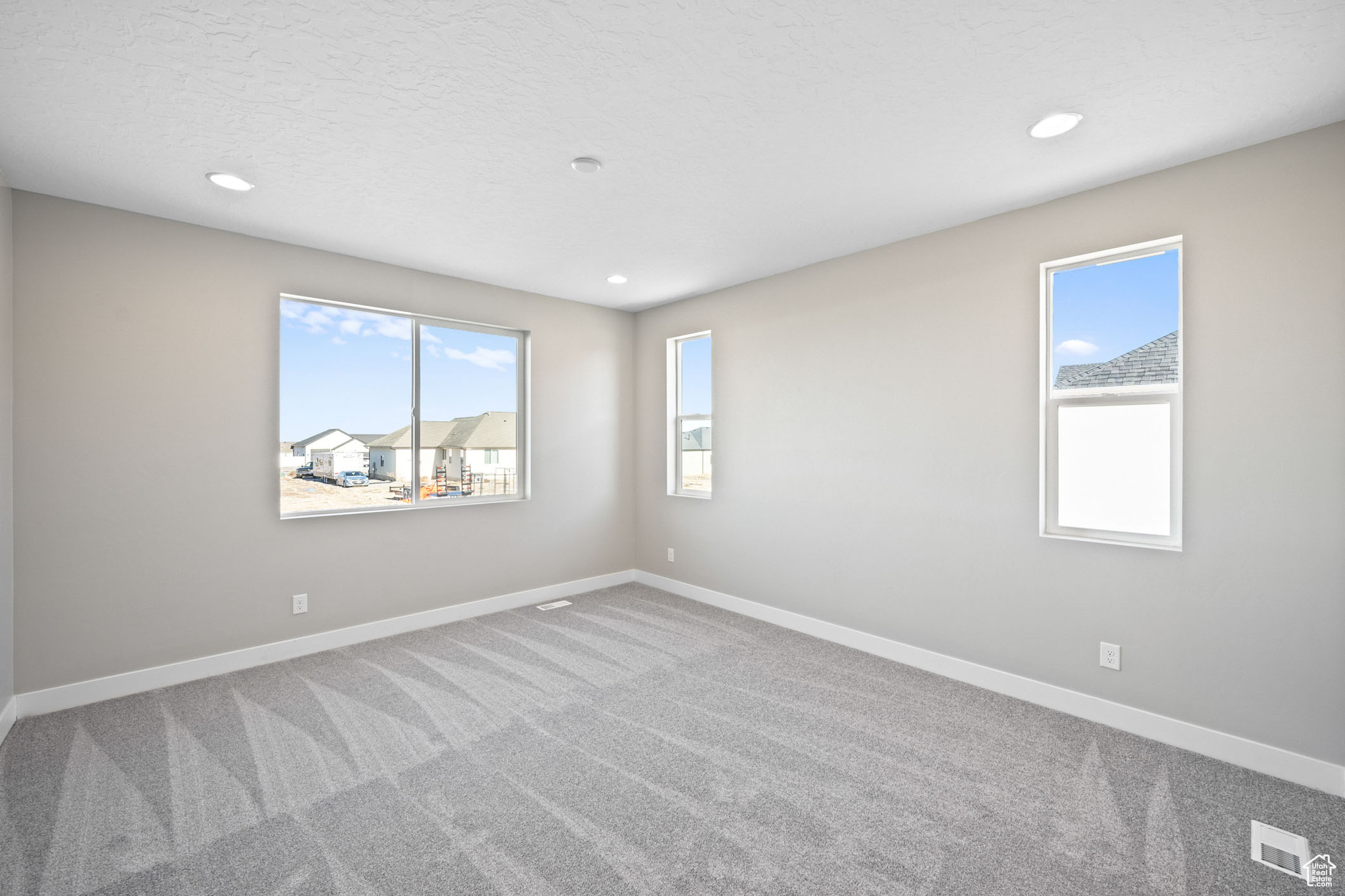 Empty room with carpet floors and a textured ceiling