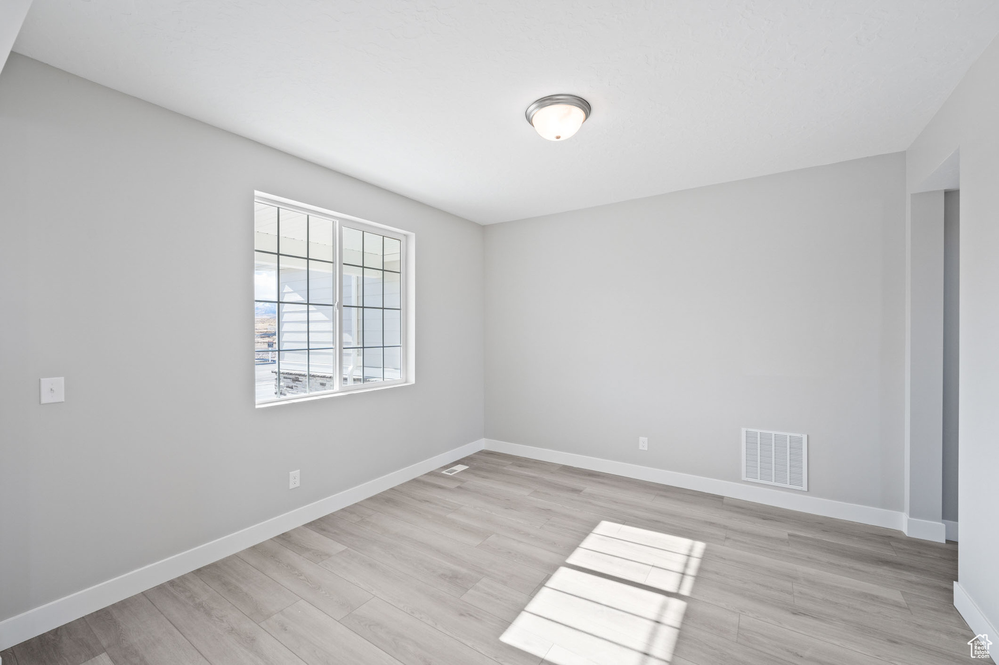 Unfurnished room with light wood-type flooring