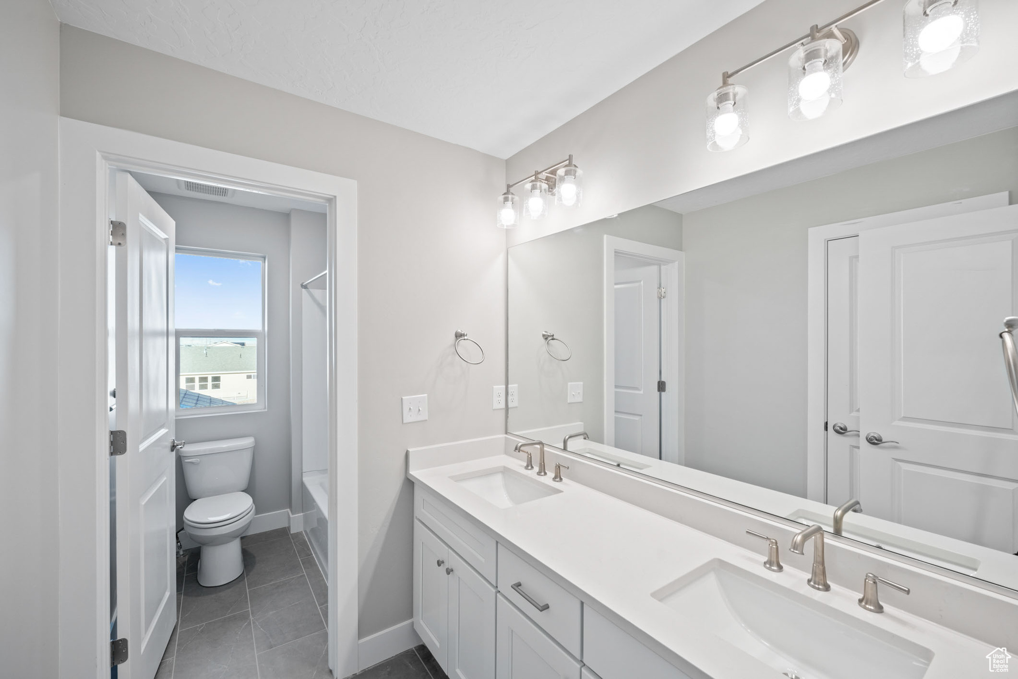 Full bathroom with vanity, tile patterned flooring, bathing tub / shower combination, and toilet