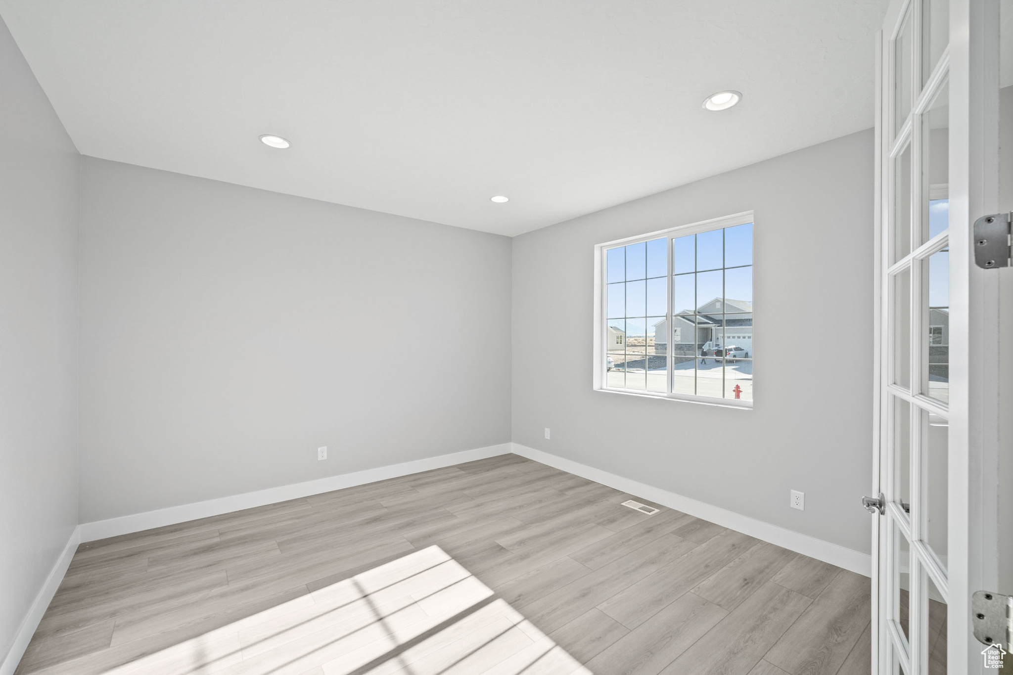Spare room featuring french doors and light hardwood / wood-style floors