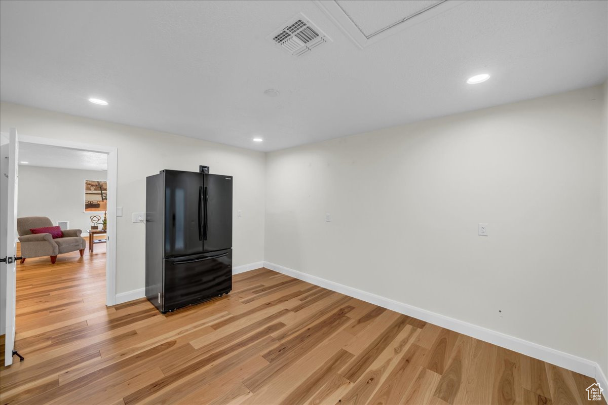 Interior space featuring black refrigerator and hardwood / wood-style floors