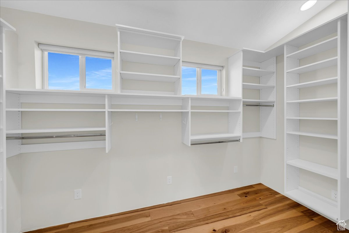 Walk in closet with vaulted ceiling and hardwood / wood-style floors