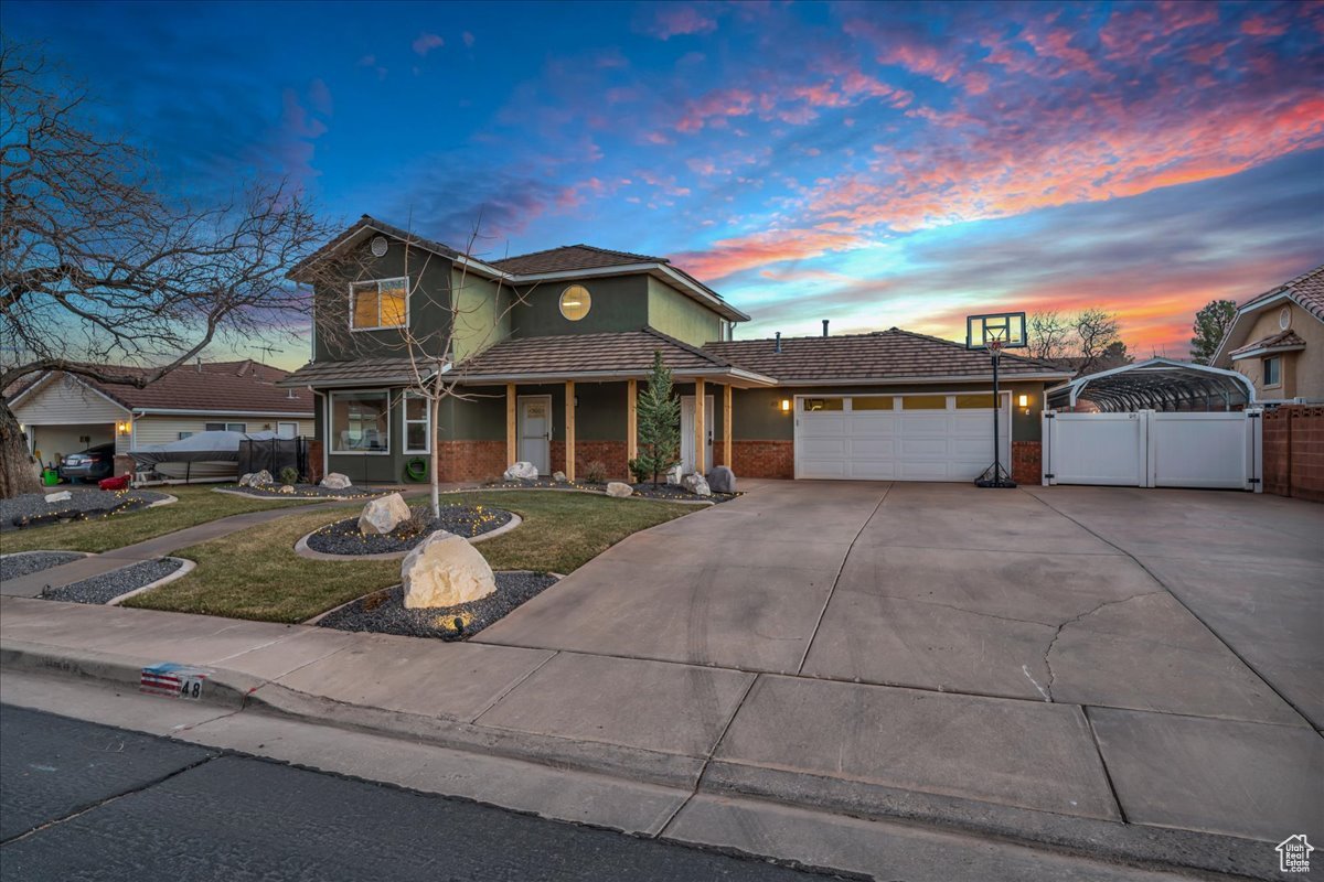 View of front of home featuring a garage and a yard