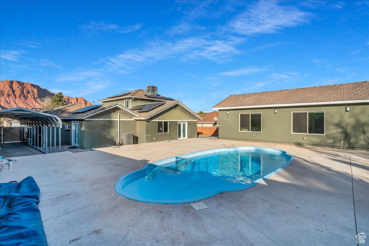 View of swimming pool featuring a mountain view, central AC, and a patio area