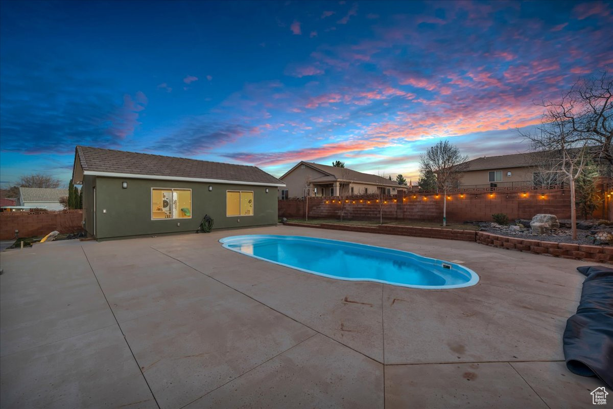 Pool at dusk with a patio area