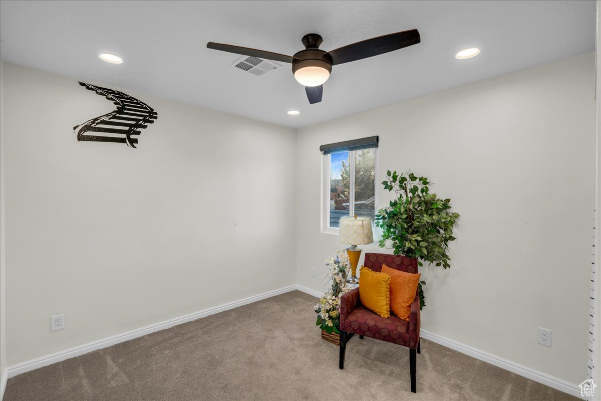 Sitting room with light colored carpet and ceiling fan