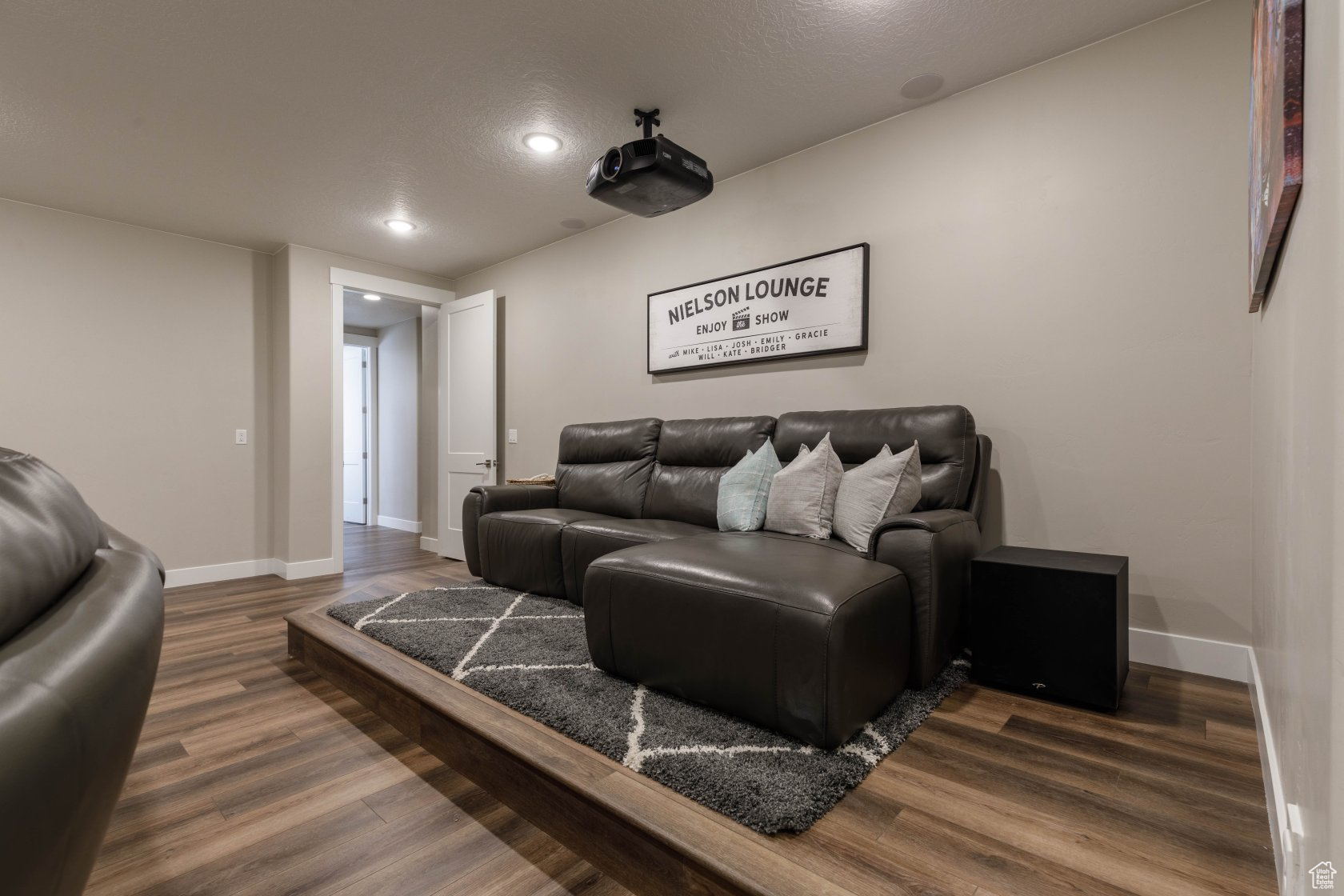 Home theater room with dark wood-type flooring