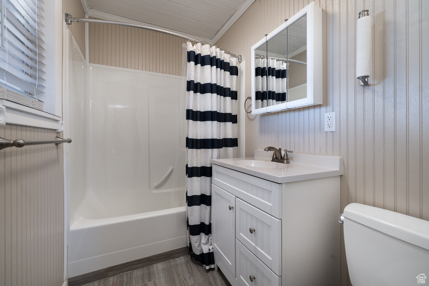 Full bathroom with shower / tub combo with curtain, wood-type flooring, toilet, and vanity