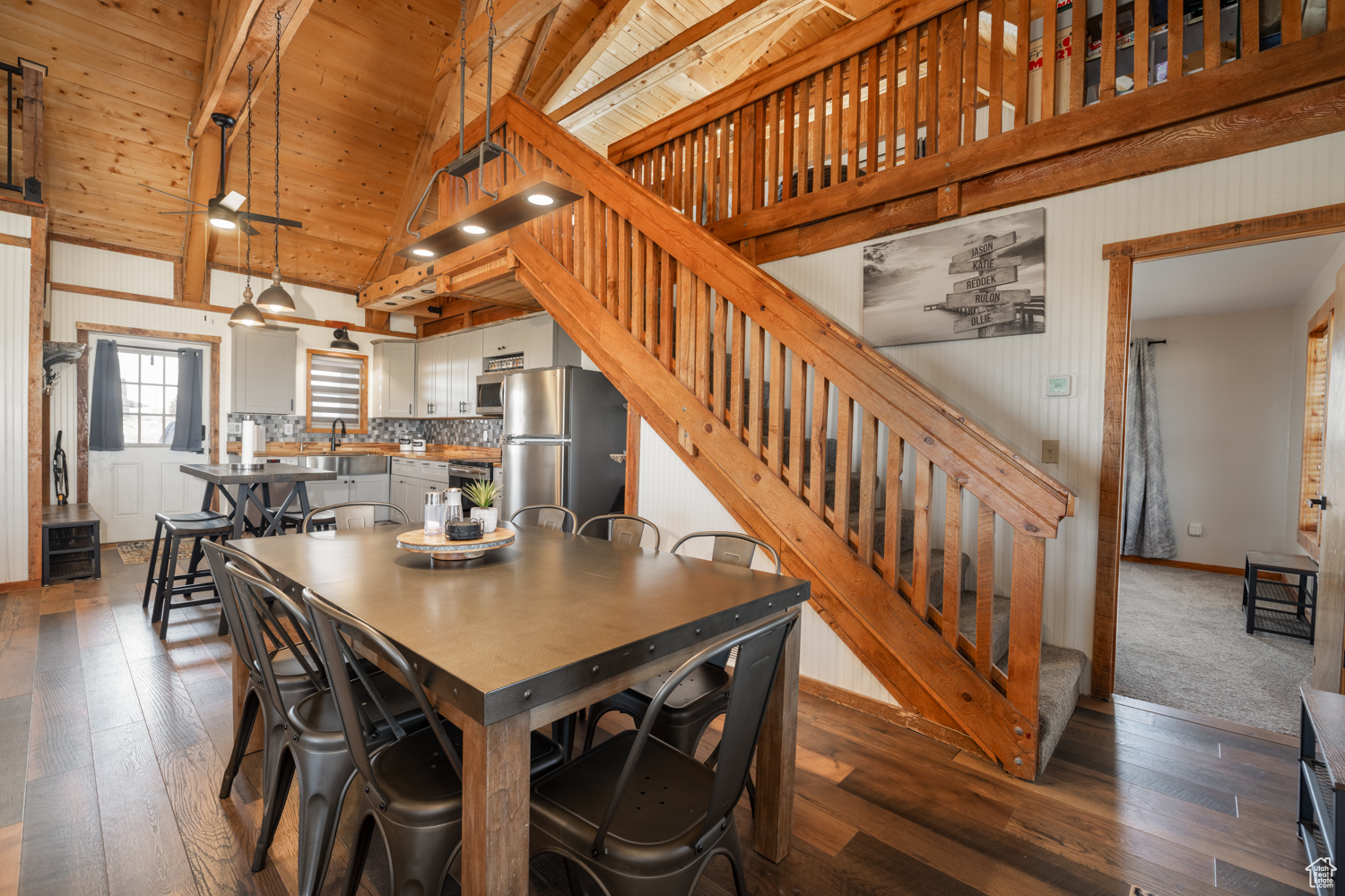 Dining area featuring sink, dark wood-type flooring, beam ceiling, high vaulted ceiling, and wooden ceiling