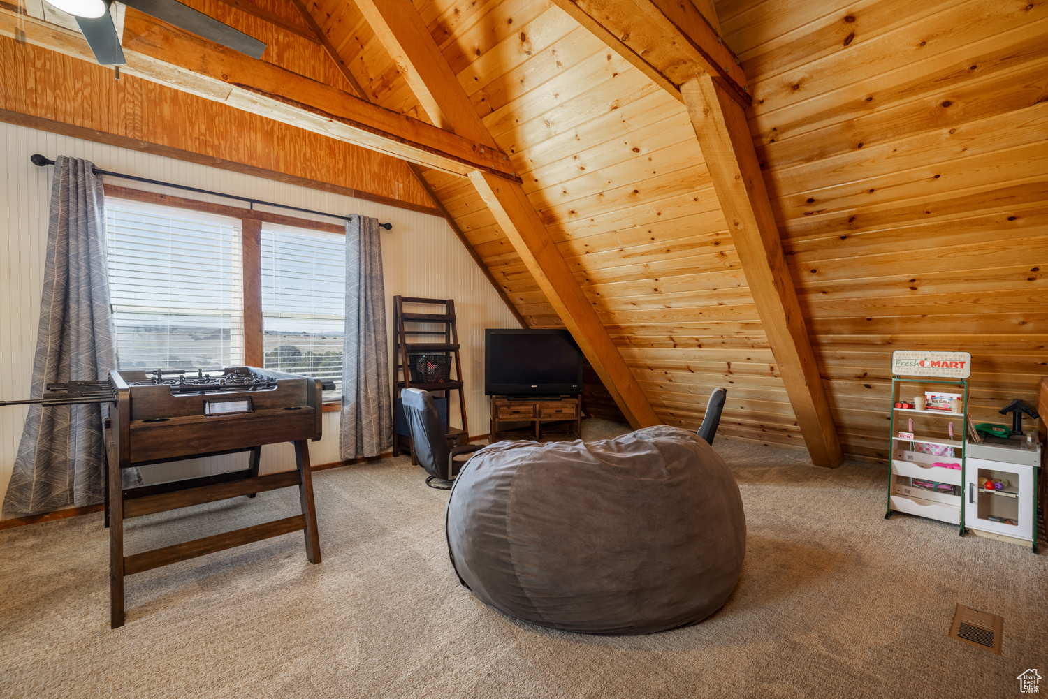 Sitting room featuring lofted ceiling with beams, wooden walls, light carpet, and wood ceiling