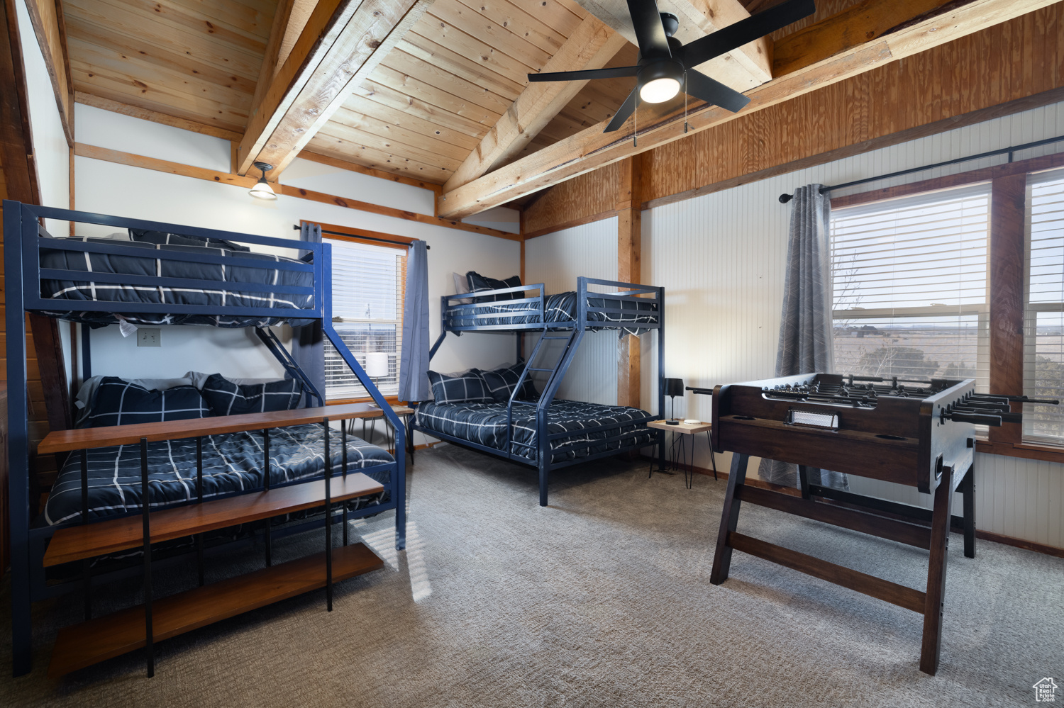 Bedroom with lofted ceiling with beams, carpet floors, wood ceiling, and wood walls