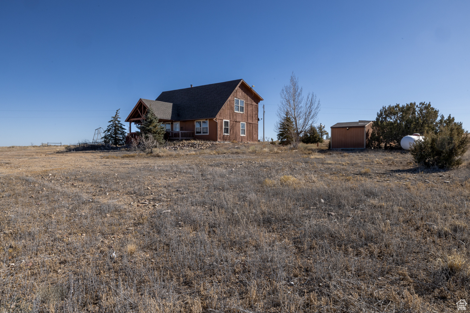 View of front of property featuring a rural view and a storage shed