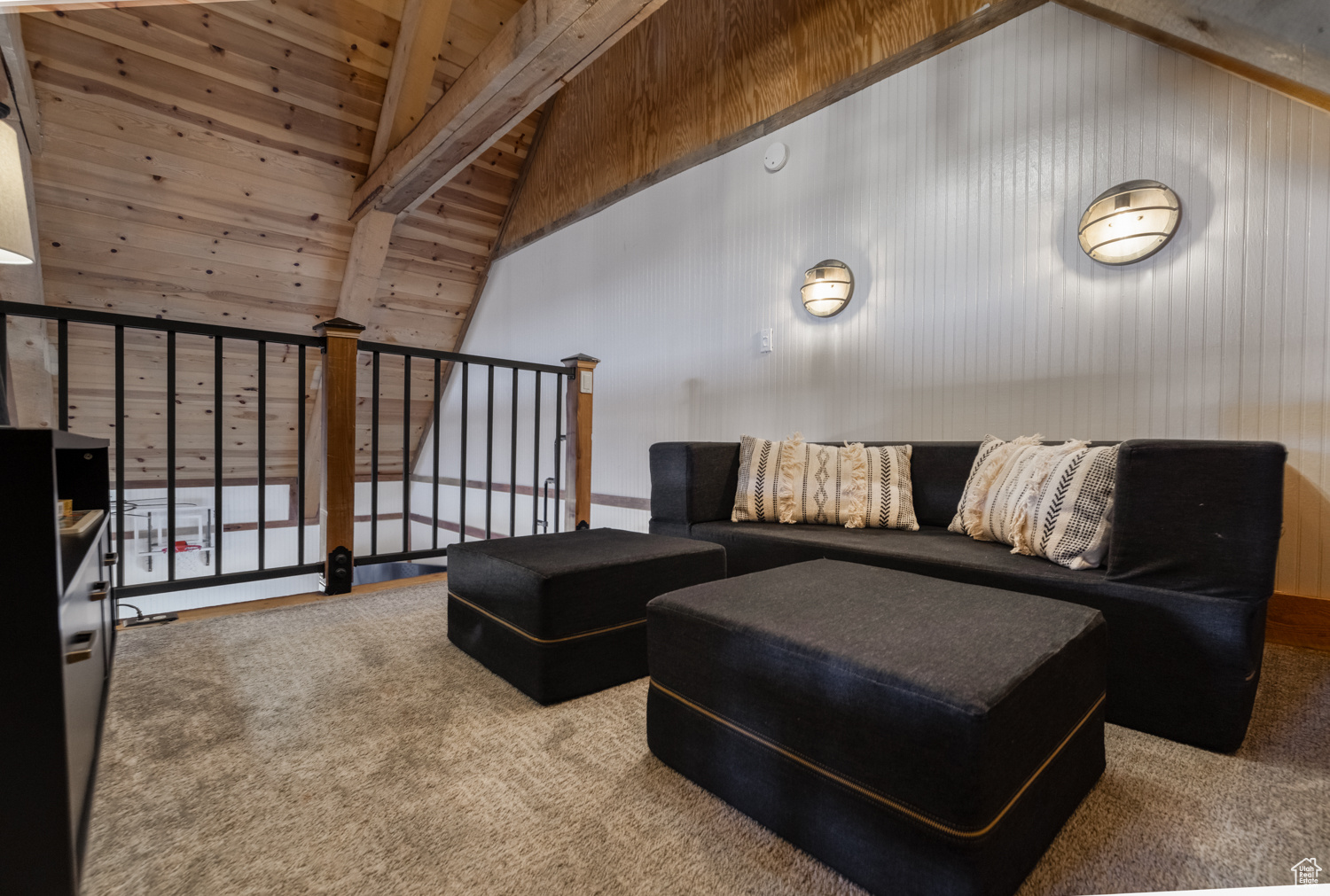 Carpeted living room featuring beamed ceiling, wooden walls, high vaulted ceiling, and wooden ceiling