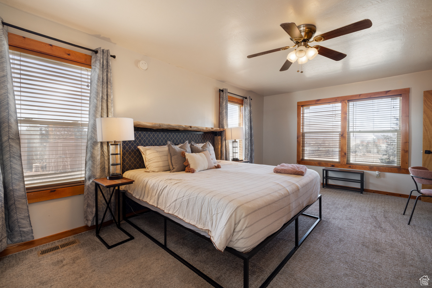 Bedroom featuring multiple windows, carpet, and ceiling fan