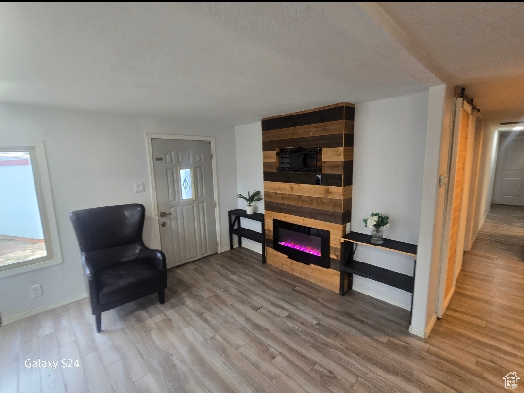 Living area featuring hardwood / wood-style flooring and a large fireplace