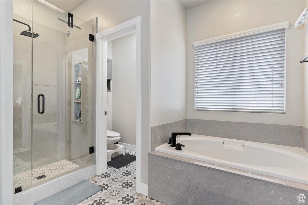 Bathroom featuring toilet and plus walk in shower