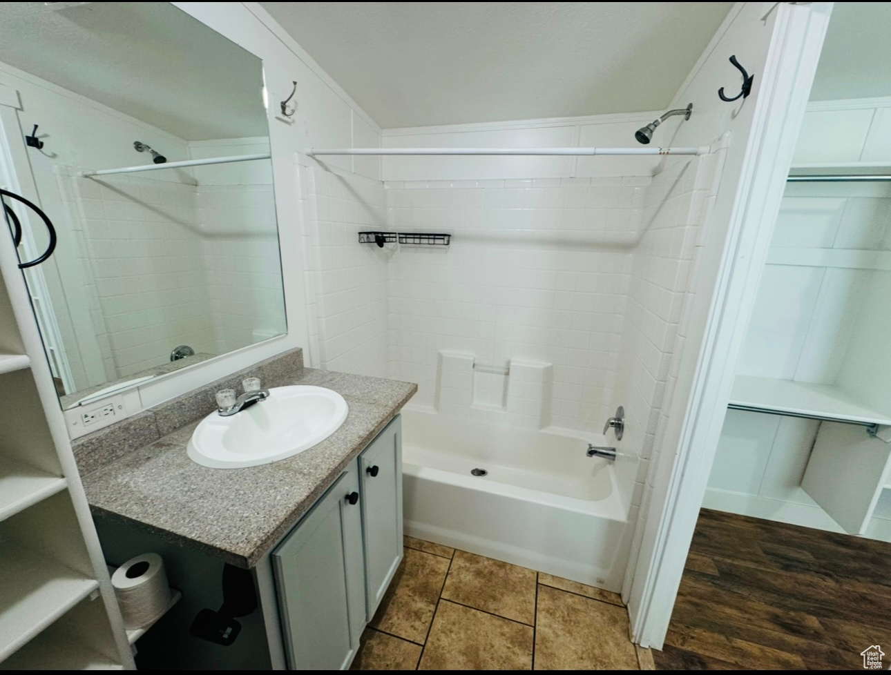 Bathroom featuring tiled shower / bath combo, vanity, and tile patterned floors