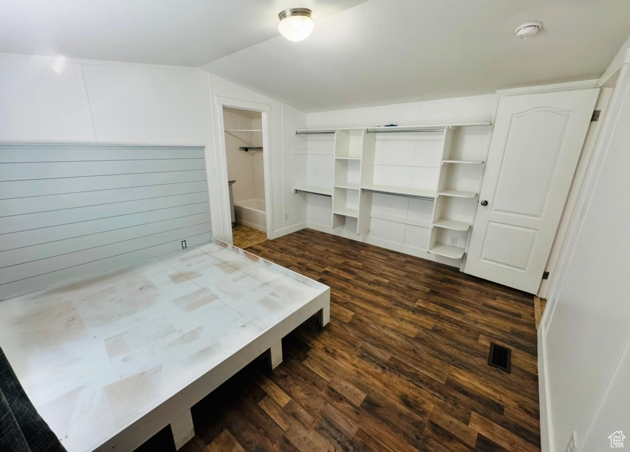 Bedroom with dark hardwood / wood-style floors and vaulted ceiling