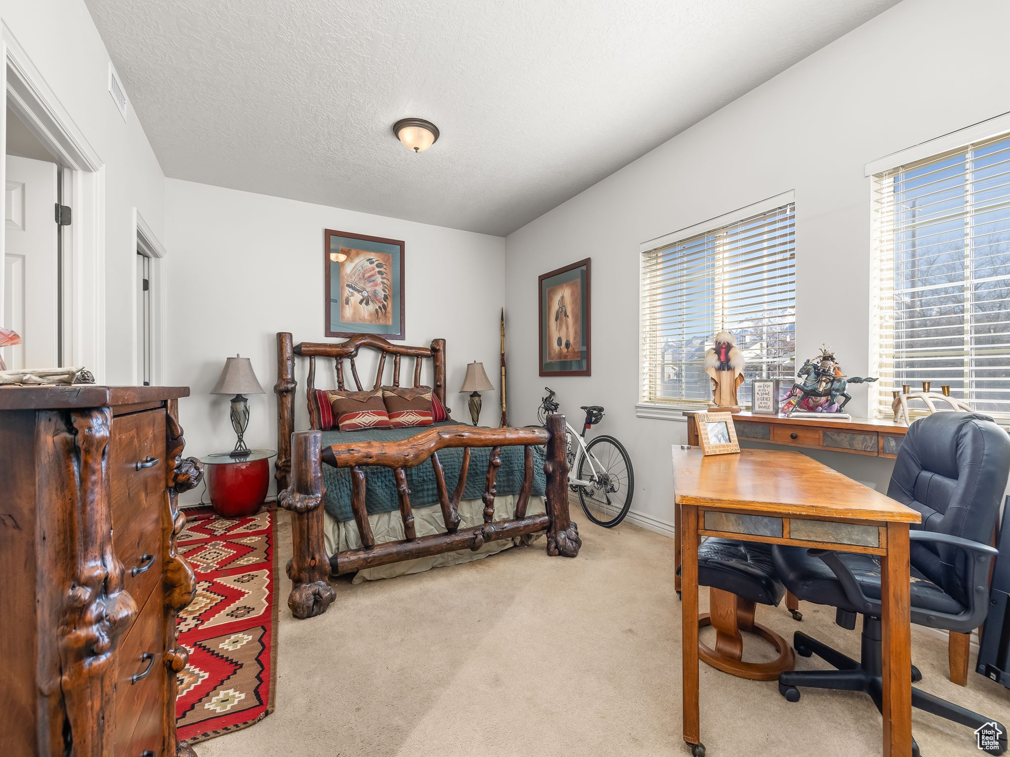 Carpeted bedroom with multiple windows and a textured ceiling