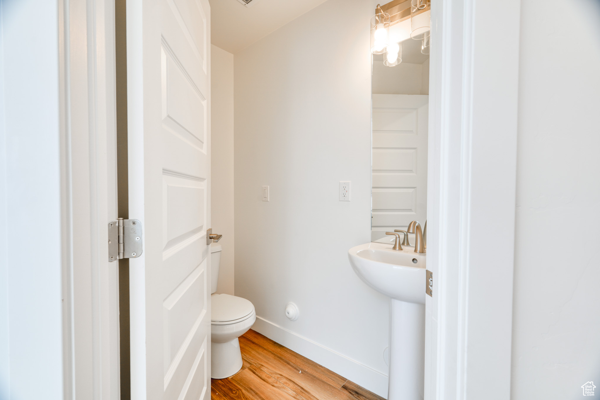 Bathroom featuring sink, hardwood / wood-style floors, and toilet