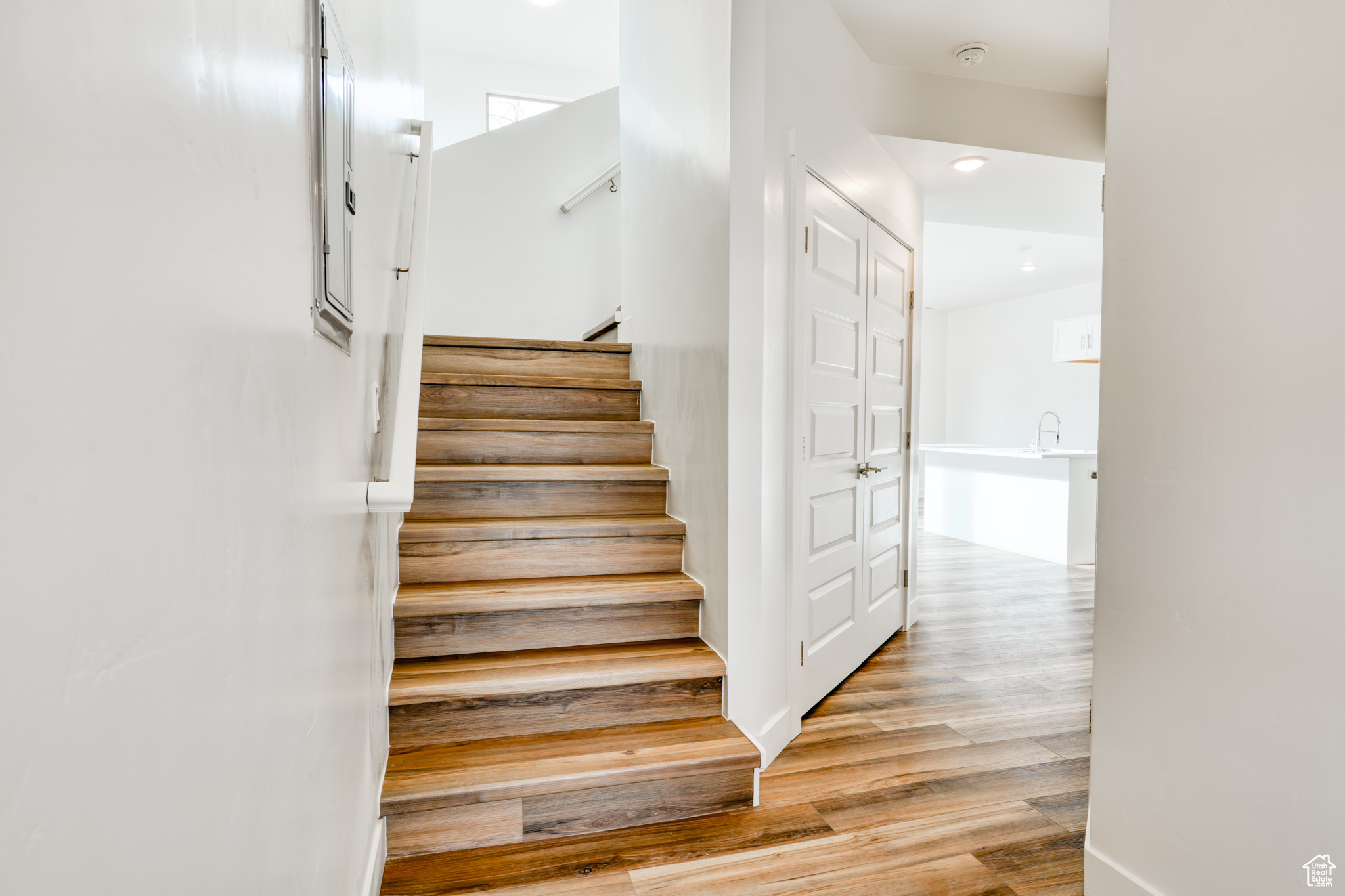 Stairway with hardwood / wood-style floors and sink