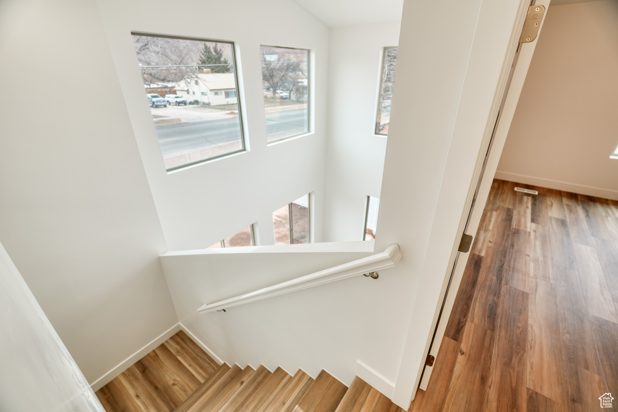 Staircase featuring lofted ceiling and hardwood / wood-style flooring
