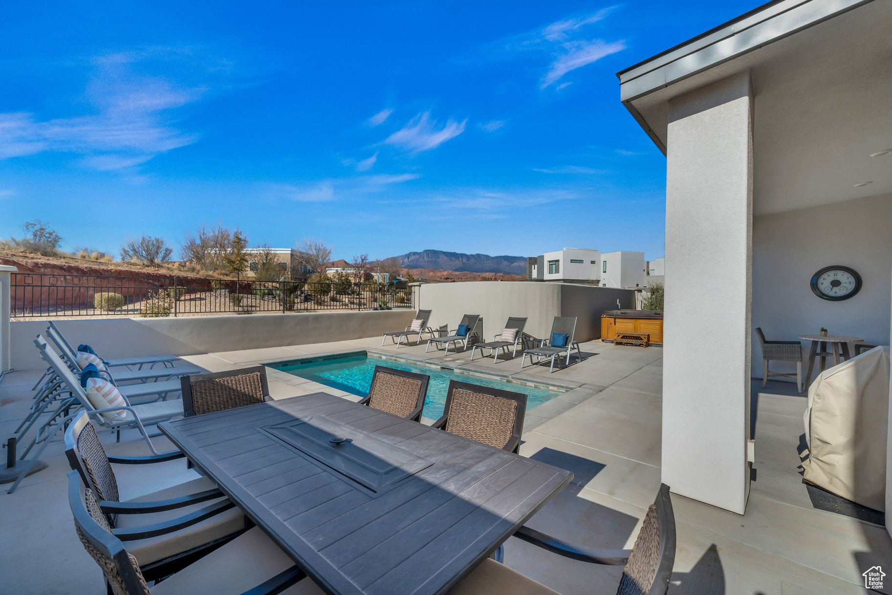 View of patio with a swimming pool with hot tub and a mountain view