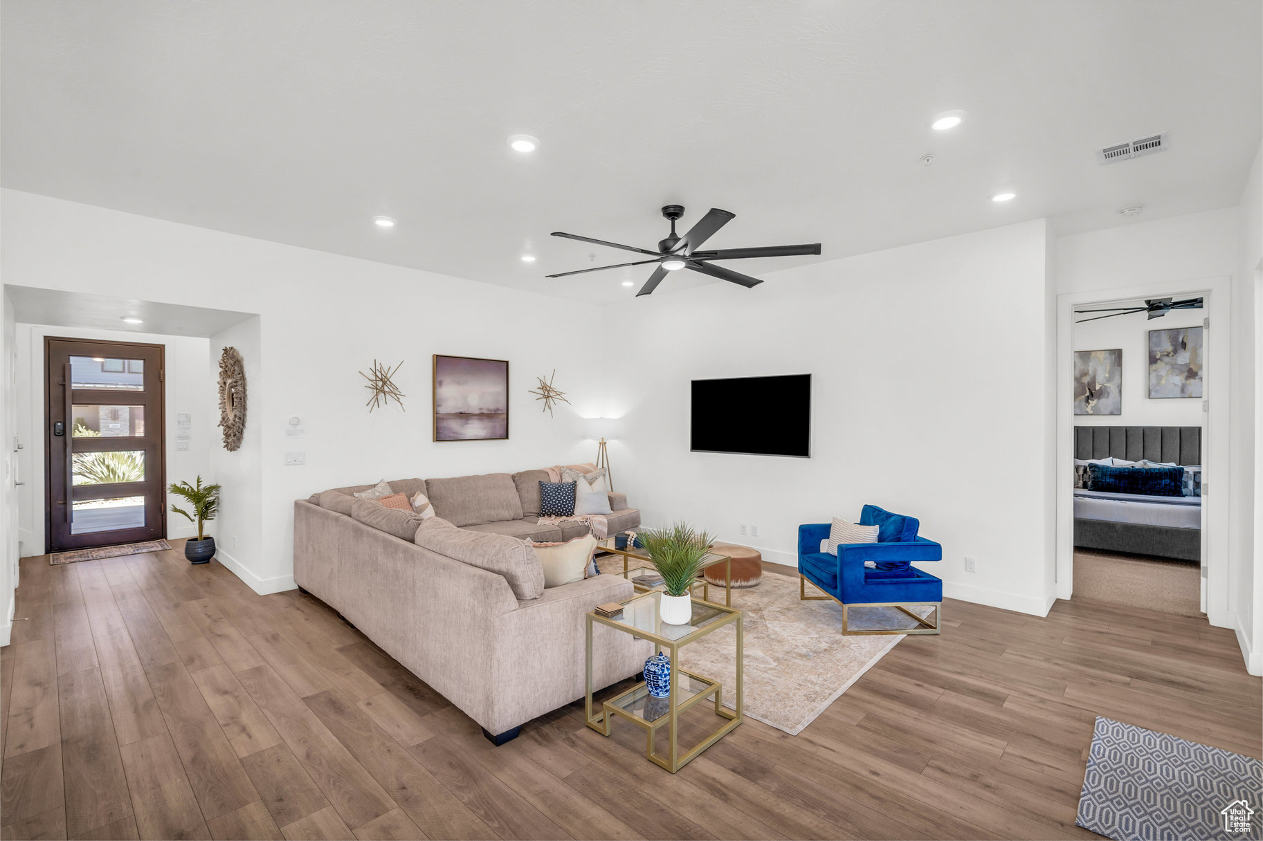 Living room with ceiling fan and light wood-type flooring