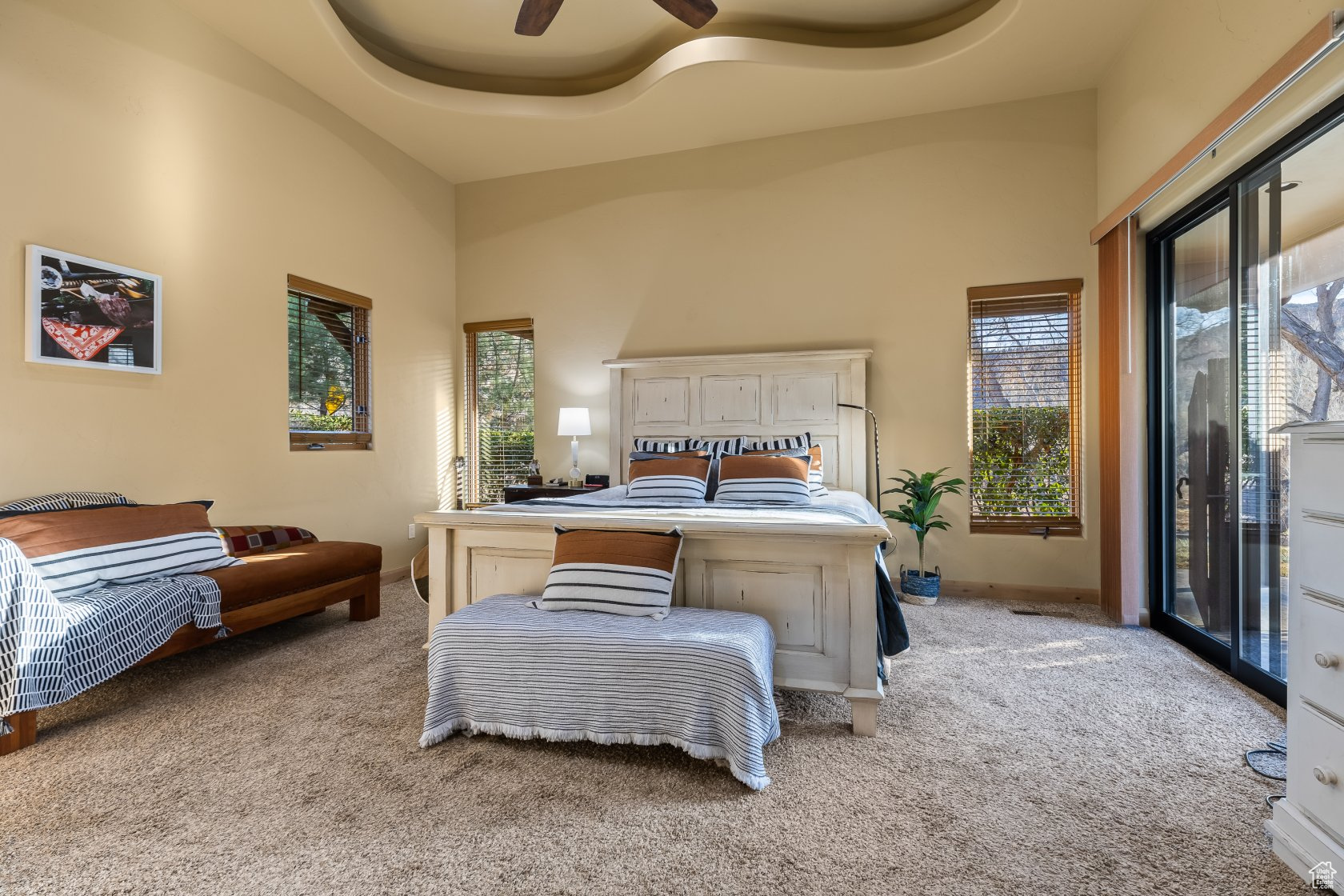 Bedroom featuring a high ceiling, access to outside, and light carpet
