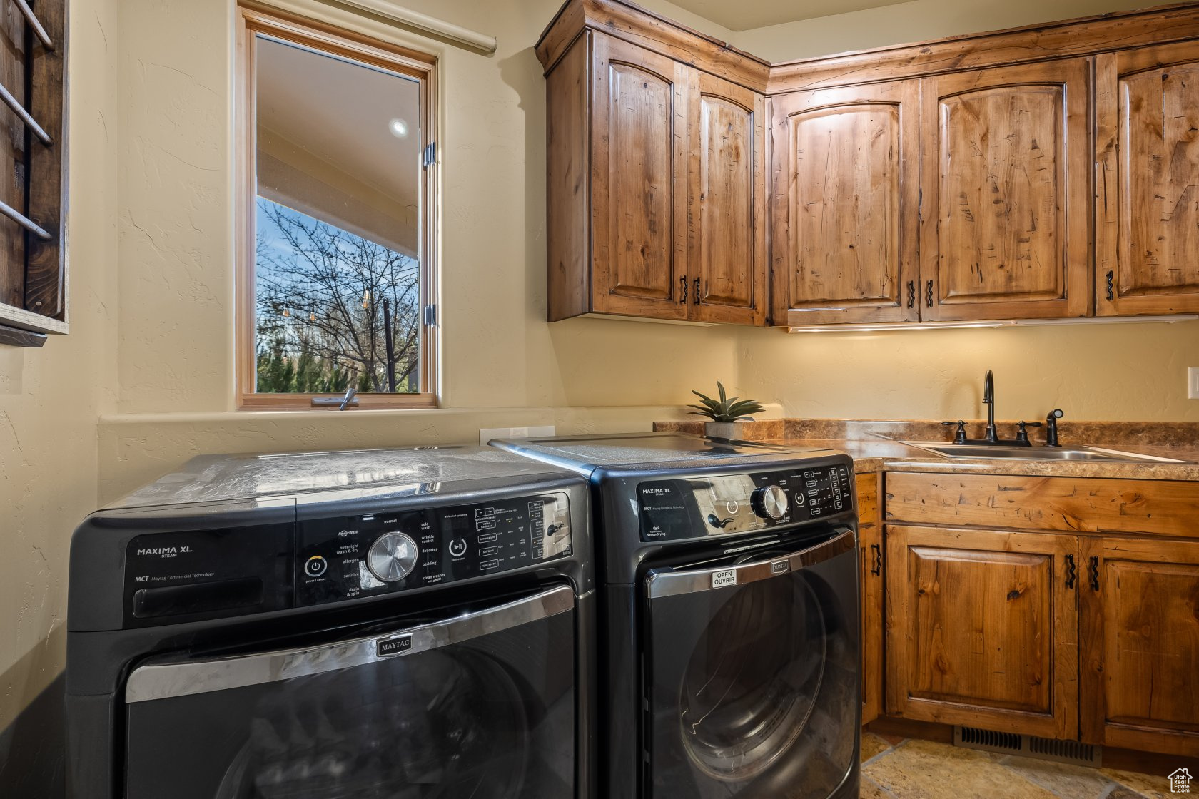 Clothes washing area featuring cabinets, independent washer and dryer, and sink