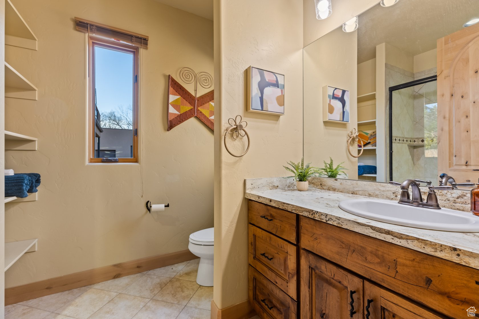 Bathroom featuring vanity, toilet, an enclosed shower, and tile patterned flooring